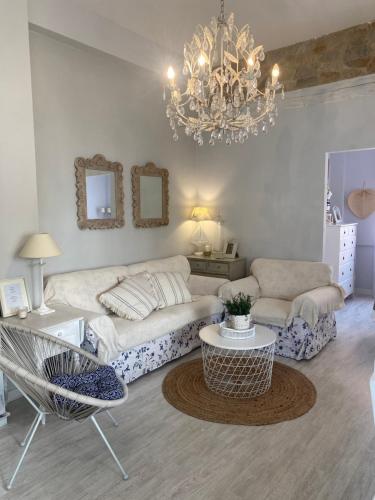 a living room with a couch and a chandelier at Casita Boutique en la playa in Sant Antoni de Calonge
