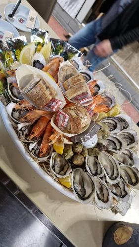 un plateau d'huîtres et d'autres aliments sur une table dans l'établissement studio a 800m de la plage , parking privé, à Sète