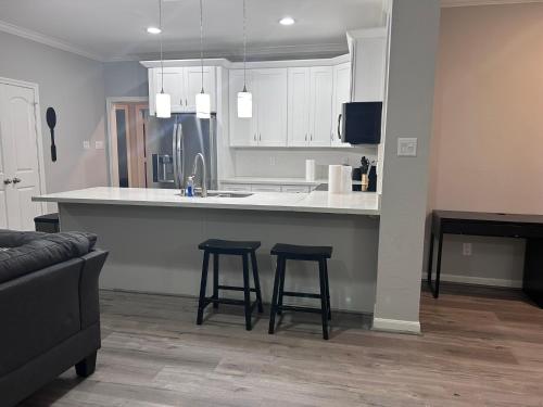 a kitchen with two bar stools and a kitchen counter at Stunning 3BR Home Near Downtown Houston - Sleeps 8 in Houston