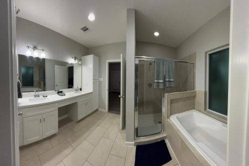a bathroom with two sinks and a shower and a tub at Stunning 3BR Home Near Downtown Houston - Sleeps 8 in Houston