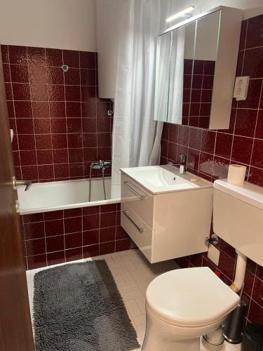 a bathroom with a toilet and a tub and a sink at Baroness von Kitzsteinblick am See in Maishofen