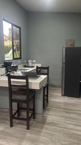 a kitchen with a table with chairs and a refrigerator at Villa Heliconias in Alajuela City