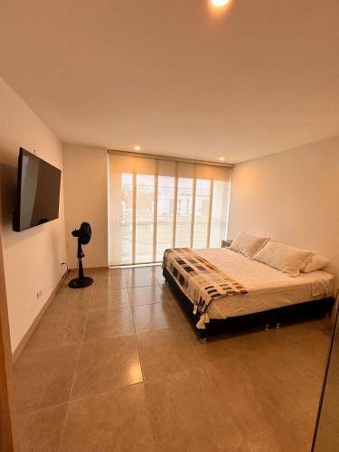 a bedroom with a bed and a flat screen tv at Belmonte Studio 311 in Armenia