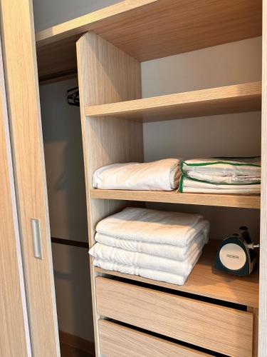 a closet with wooden shelves with folded towels at Belmonte Studio 311 in Armenia