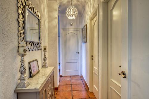 a hallway with a white door and a tile floor at Casa Hollandia in Viñuela