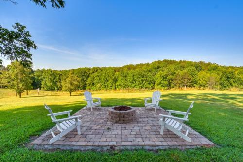 three white chairs and a fire pit in the grass at Home with Fire Pit on 27 Acres in Walhalla! in Walhalla