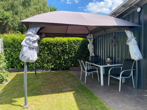 a patio umbrella with a table and chairs under it at Neu Apartment in Schloß nähe,Parkplatz, Netflix in Sögel