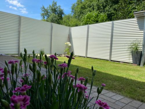 a garden with purple flowers and a fence at Neu Apartment in Schloß nähe,Parkplatz, Netflix in Sögel