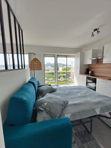 une chambre avec un lit et un canapé bleu dans l'établissement Splendide T2, 200m de la mer, climatisé, parking, à Cagnes-sur-Mer