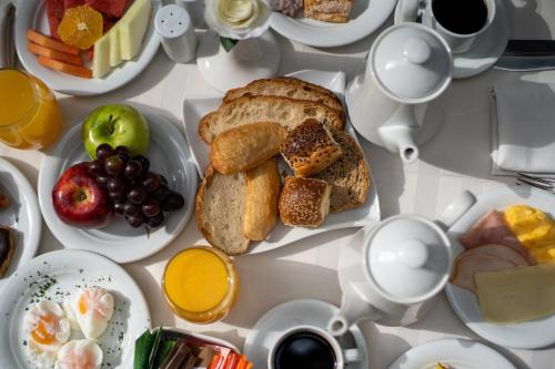 a table topped with plates of breakfast foods and coffee at Crowne Plaza Asunción by IHG in Asuncion