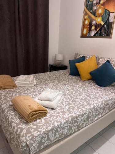 - un lit avec des oreillers bleus et jaunes dans l'établissement Studio au cœur de la ville d’Arles, à Arles