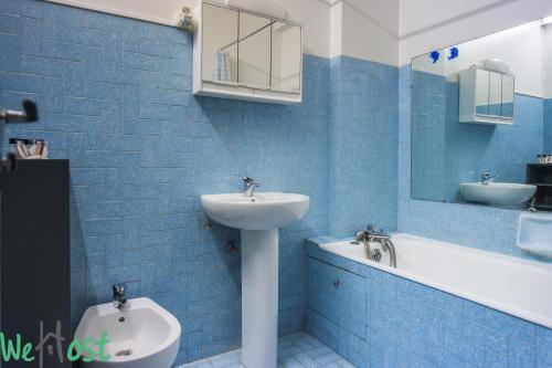 La salle de bains est pourvue de carrelage bleu, d'un lavabo et de toilettes. dans l'établissement Riquier Downtow 2P proche Gare, Tram & Parking, à Nice