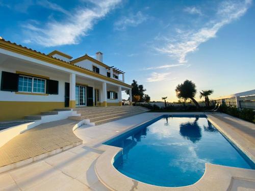 a swimming pool in front of a house at Vivenda Soares in Estômbar