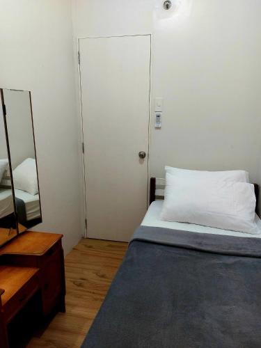 Un dormitorio pequeño con una cama y un espejo. en Dazzling Dash Suite, en Naga