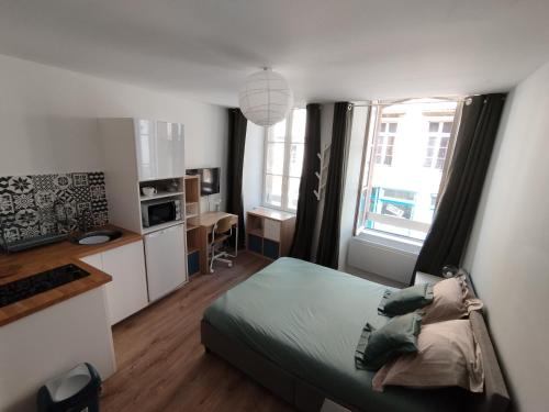 a small bedroom with a bed and a kitchen at Studio - Centre-ville in Morlaix