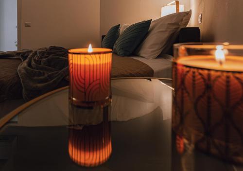 two candles sitting on a glass table in a living room at Tower View luxury apartment on the River in Pisa