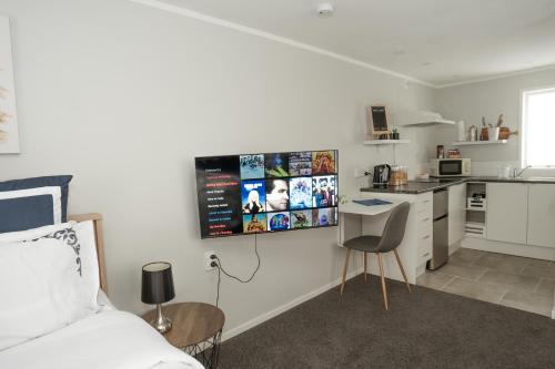 a bedroom with a bed and a small kitchen at The Billy Hilton in Tauranga