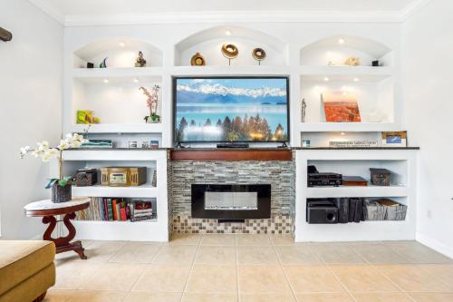 a living room with a fireplace with white shelves at Cape Paradise B & B - Your Luxury Tropical Retreat in Cape Coral