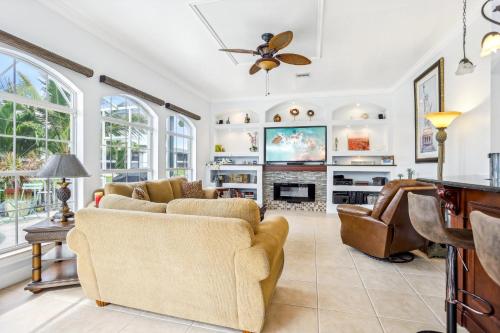 a living room with couches and a tv at Cape Paradise B & B - Your Luxury Tropical Retreat in Cape Coral
