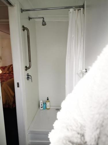 a bathroom with a shower with a white curtain at Affordable and convenient accommodation in Toowoomba
