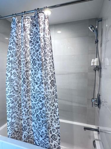 a shower curtain in a bathroom next to a tub at Monthly stay-Relocation Special-New condo at Metrotown in Burnaby