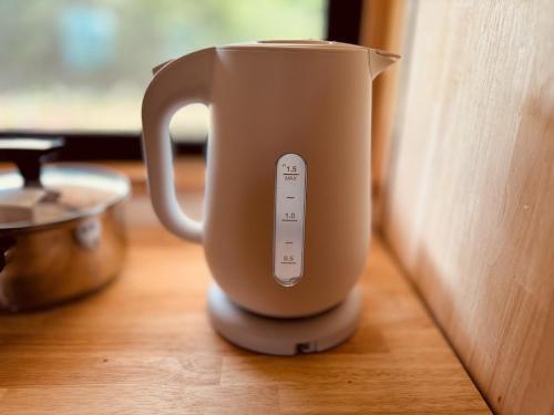 a cup with a remote control sitting on a table at Villa 天ツ星 in Tahara