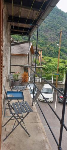 a blue chair sitting on a porch with a car at Casa Leventina in Giornico