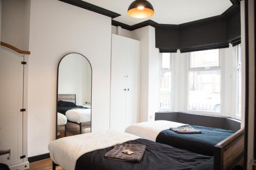 a bedroom with two beds and a mirror at Entire Modern Home in Manchester and Near Peak District in Manchester
