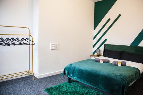 a bedroom with a bed with a green bedspread at Entire Modern Home in Manchester and Near Peak District in Manchester