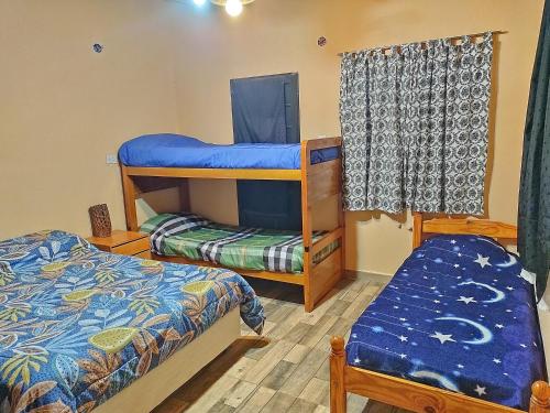 a room with two bunk beds and a bench at Cabaña Los Cardones in Campanas