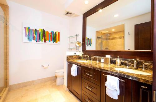 a bathroom with two sinks and a large mirror at 360 Splendor 101A Ocean View Breakfast in Playa Flamingo