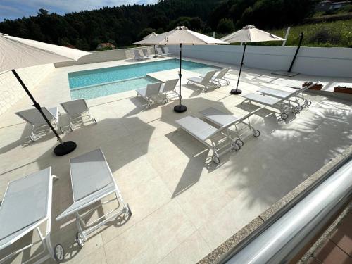 an overhead view of a pool with chairs and umbrellas at Naturmar in Raxó