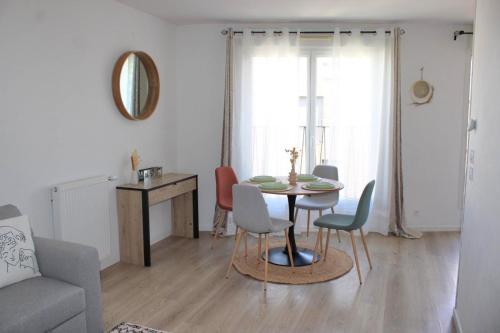 un salon avec une table et des chaises dans l'établissement Appartement élégant et lumineux, à Romainville