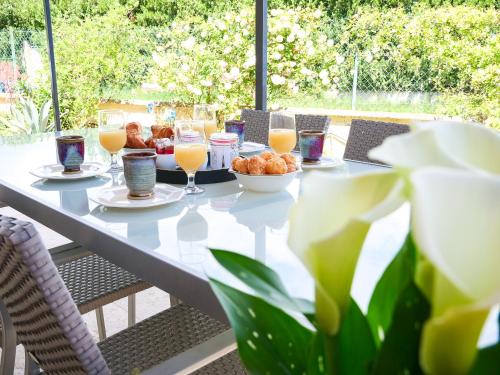une table avec une assiette de nourriture et des verres de jus d'orange dans l'établissement Le Mazet de St Laurent - 4 personnes - Idéalement situé, à Saint-Laurent-dʼAigouze