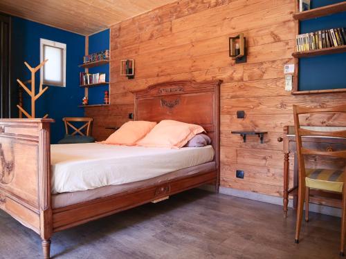 Un dormitorio con una cama con una pared de madera. en Le Mazet de St Laurent - 4 personnes - Idéalement situé, en Saint-Laurent-dʼAigouze