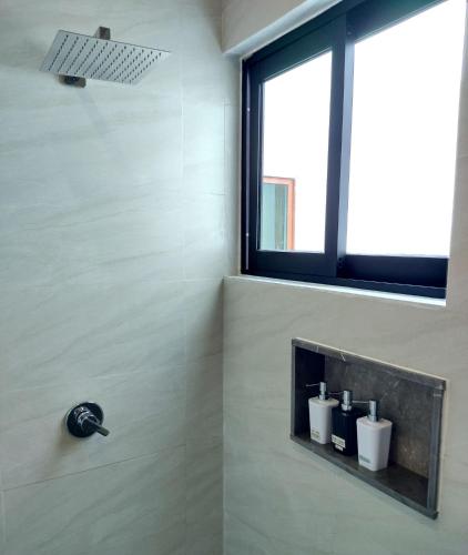 a bathroom with a shower with a window at Villa Tucanes in Tulum