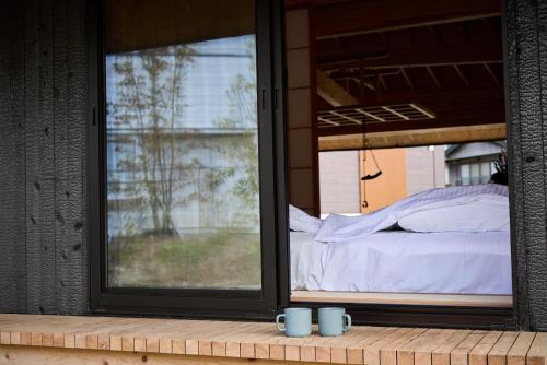 a room with a window with two mugs and a bed at Villa 天ツ星 in Tahara