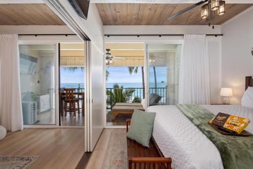 a bedroom with a bed and a view of the ocean at Ocean-front penthouse, sunsets, whales, surfers! Newly remodeled! in Kailua-Kona