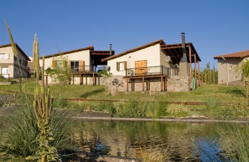 a group of houses next to a body of water at Aguilas de Piedra in Cacheuta