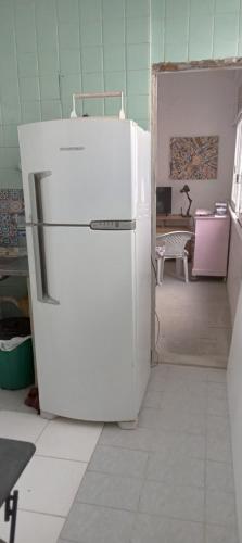 a white refrigerator in a room with a kitchen at Luz de Regina Hospedagem in Salvador
