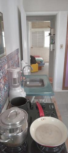 a kitchen counter with a stove top with pots and pans at Luz de Regina Hospedagem in Salvador