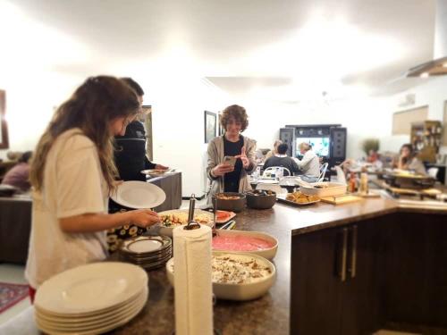 a group of people preparing food in a kitchen at Carlo's Boutique Guesthouse in Walvis Bay