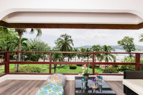 a balcony with a view of the ocean and palm trees at Flamingo Marina Cove 404- Oceanfront Condo in Playa Flamingo