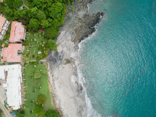 an overhead view of a beach and the ocean at Flamingo Marina Cove 404- Oceanfront Condo in Playa Flamingo