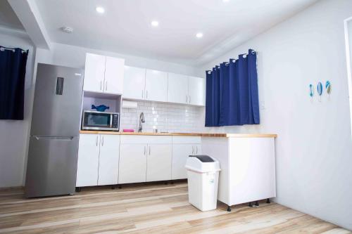 a kitchen with white cabinets and a refrigerator at Casa Rosado Rincon Rayo Suite Mountain View Pool in Rincon