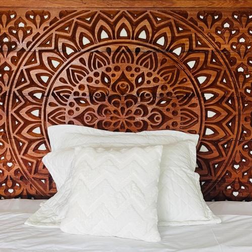 a bed with a wooden headboard and a white pillow at Fundo Shanti in Lamas