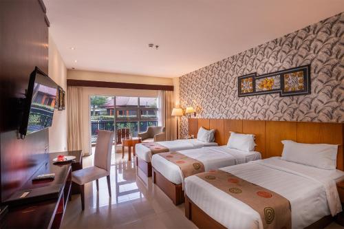 a hotel room with two beds and a television at Griya Persada Convention Hotel & Resort Bandungan in Bandungan
