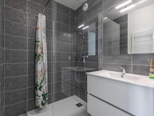 une salle de bain avec une douche, un lavabo et un miroir dans l'établissement Lodge neuf avec 3 chambres, terrasse et parking, à 5 min du centre de Cauterets - FR-1-401-298, à Cauterets