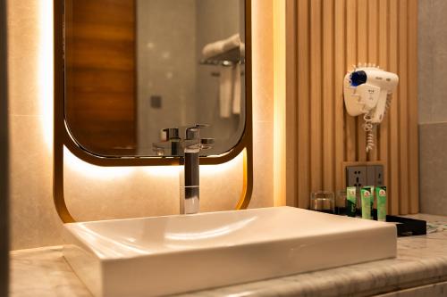 a white sink in a bathroom with a mirror at Griya Persada Convention Hotel & Resort Bandungan in Bandungan