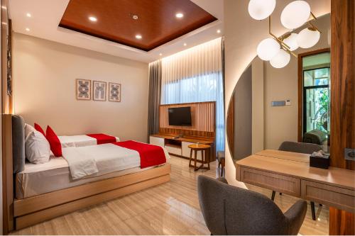 a bedroom with a bed and a desk and a table at Griya Persada Convention Hotel & Resort Bandungan in Bandungan